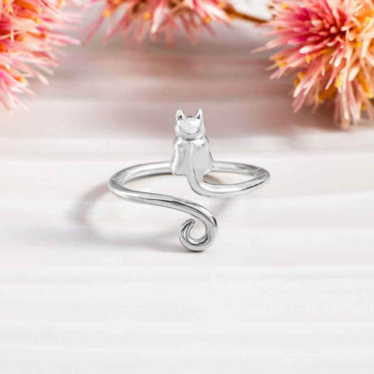 Close up of a shiny sterling silver ring for women with a cat silhouette on one side and a shiny swirl on the other.  The band is adjustable so is open in the middle. 