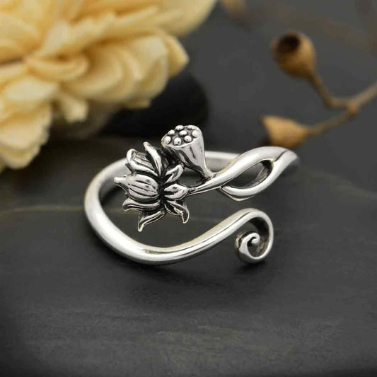 Close up of a petite lotus flower adjustable ring with a lotus and a lotus bud on one side and a shiny sterling silver swirl on the other. 